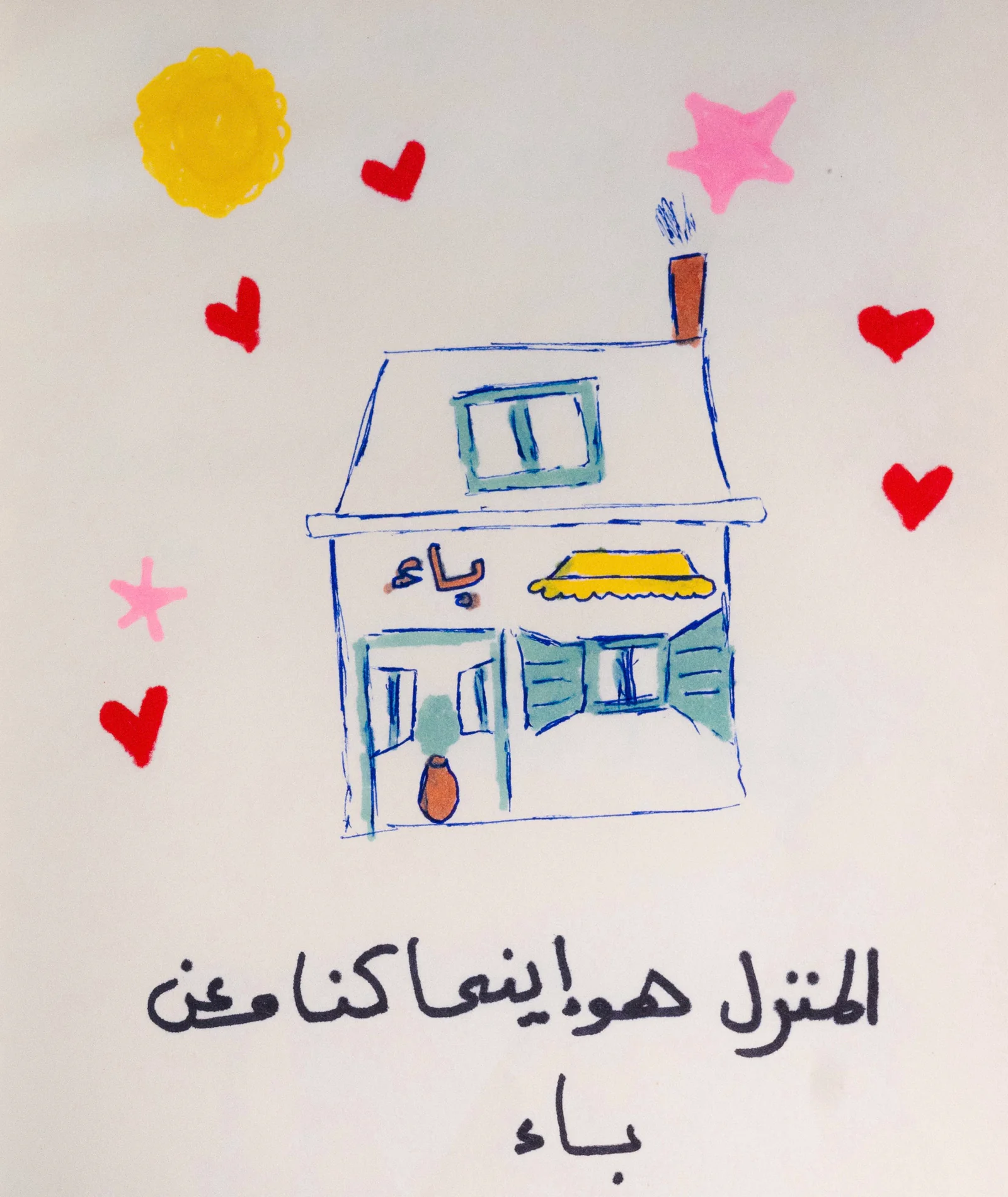 رسمة ملوّنة لبيت مكتوب عليه «باء» تحيط به قلوب ونجوم، وتحته جملة بخط اليد